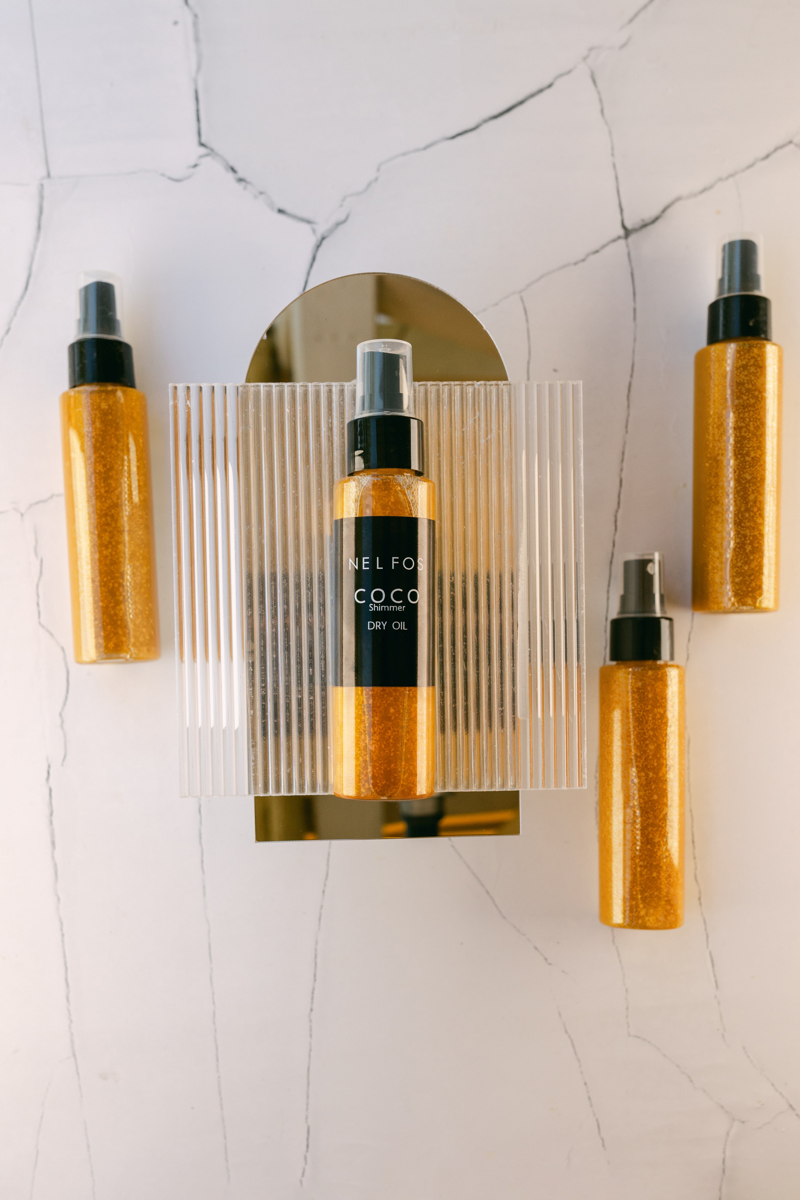 Gold bottles with black labels on a marble surface