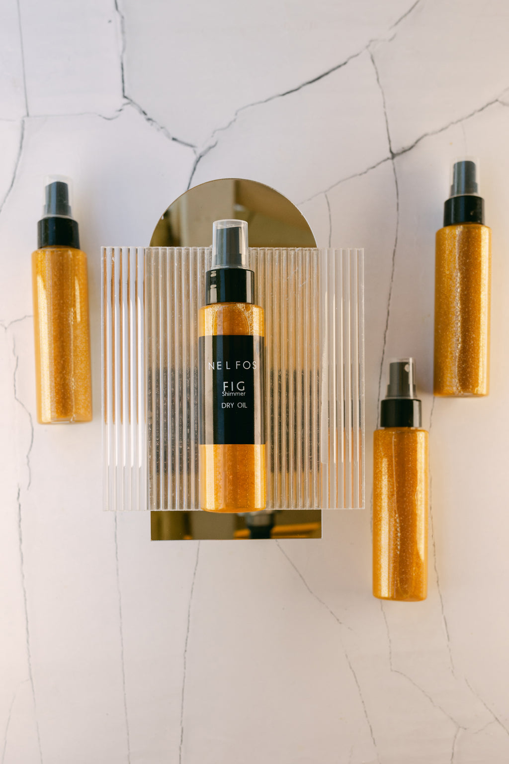 Four bottles of 'Sefko' Fig Dry Oil on a textured white surface